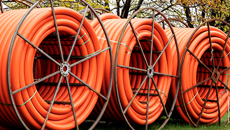 Three large reels of orange communication duct, transmission 230x130p